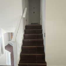 Staircase with wood finish floors and baseboards