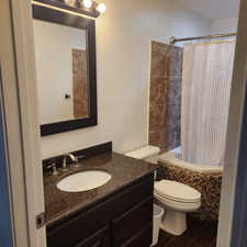 Bathroom with vanity, tiled shower / bath, and tile patterned flooring