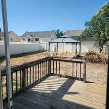 Deck featuring a gazebo, a fenced backyard, and a residential view
