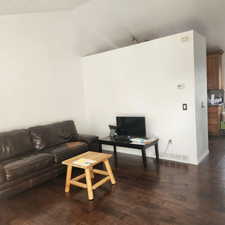 Living area with hardwood / wood-style flooring and vaulted ceiling