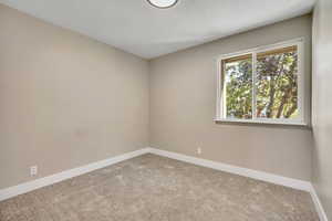 Carpeted spare room with baseboards and a textured ceiling