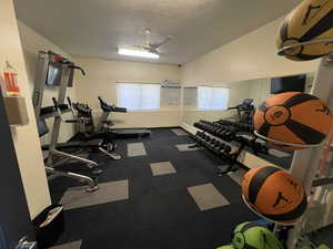 Exercise room featuring a textured ceiling and ceiling fan