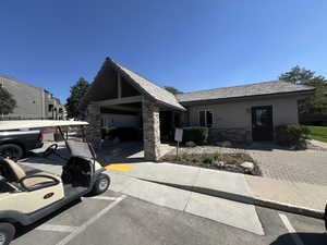 View of front of property with stone siding, stucco siding, and uncovered parking