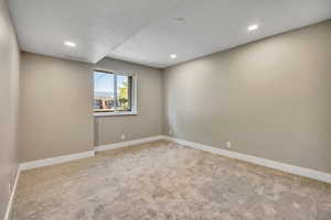 Carpeted spare room featuring baseboards and recessed lighting