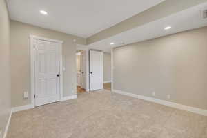 Unfurnished bedroom with recessed lighting and light colored carpet