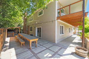 Rear view of house featuring a patio, outdoor dining area, and a wooden deck