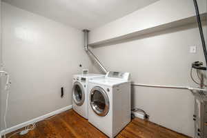 Washroom featuring washer and dryer and wood finished floors