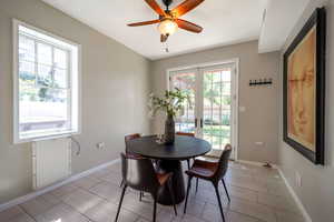 Dining room featuring french doors, ceiling fan, and wood tiled floors