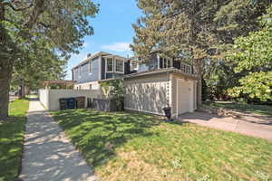 View of front of house featuring an attached garage, concrete driveway, and a chimney