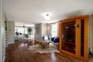 Living area with a sauna, wood finished floors, and a ceiling fan