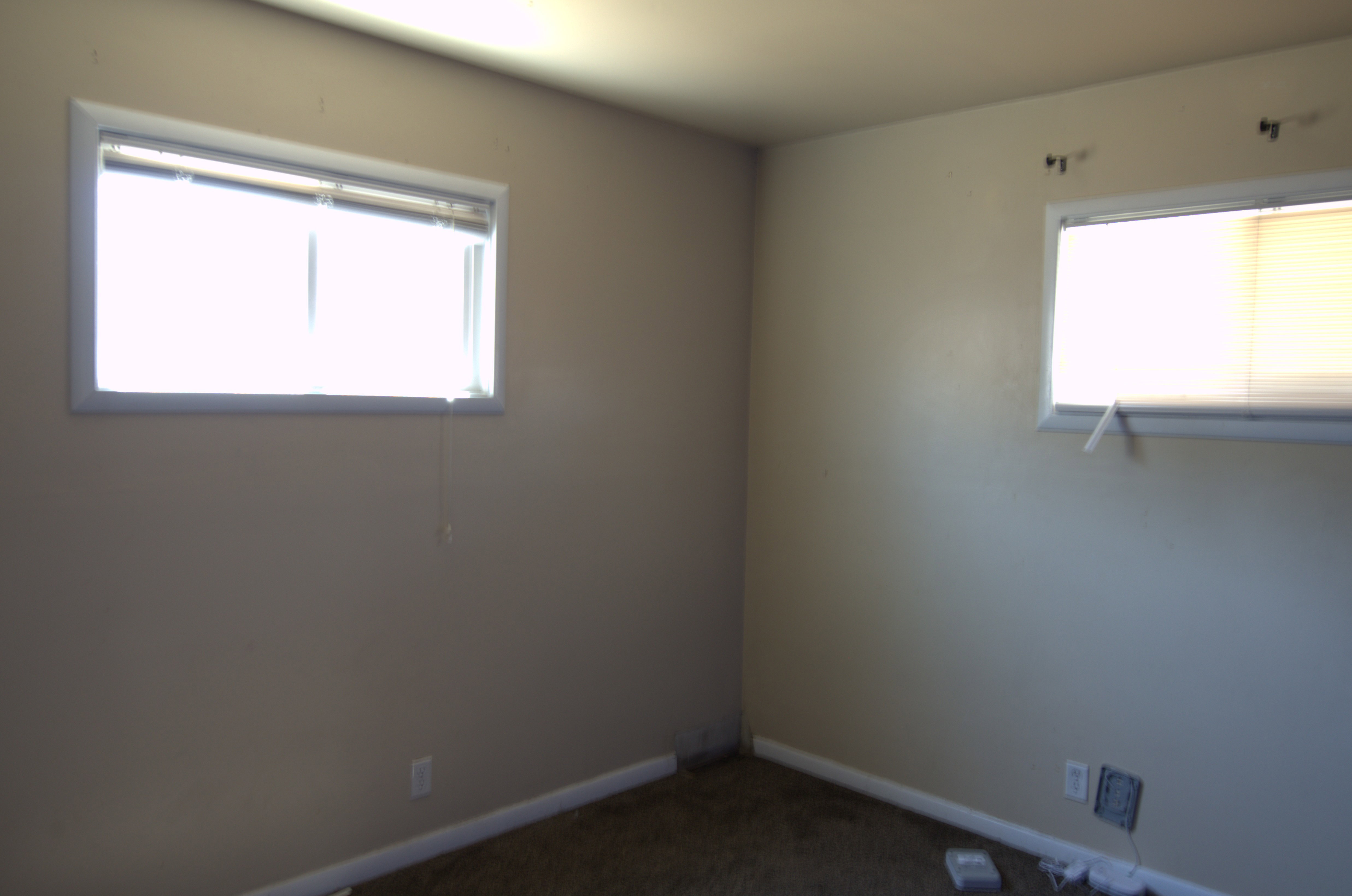 Spare room featuring dark carpet and baseboards