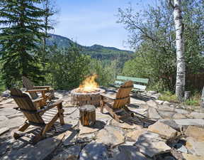 View of patio / terrace featuring a mountain view, a fire pit, and a wooded view