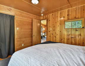 Bedroom featuring wooden walls