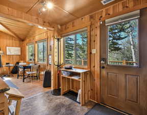 Dining area featuring lofted ceiling and wood walls