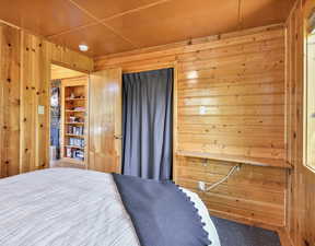 Bedroom featuring wooden walls