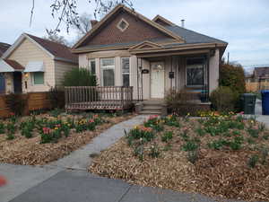 Bungalow featuring a chimney and a porch