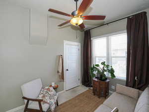 Living area with light colored carpet, a textured ceiling, and ceiling fan