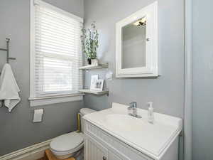 Half bathroom featuring vanity and a textured wall