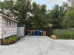 View of patio featuring a shed, view of scattered trees, and grilling area