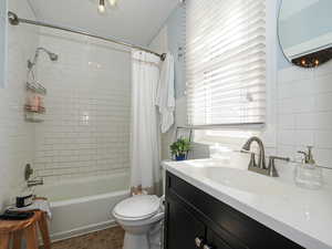 Full bath featuring shower / bathtub combination with curtain, vanity, and tile walls