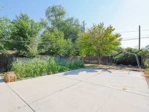 Fenced backyard featuring a carport and a patio area