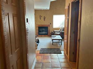 Corridor featuring a textured wall, a textured ceiling, and tile patterned floors