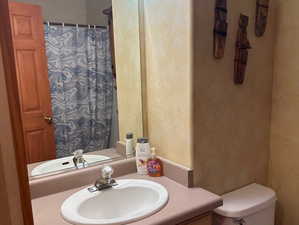 Bathroom with a textured wall, vanity, tile patterned flooring, and a shower with curtain