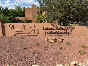 Community / neighborhood sign with view of scattered trees