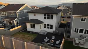 Back of house featuring an outdoor hangout area, a residential view, roof with shingles, and a fenced backyard