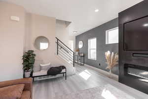 Entrance foyer with stairway, recessed lighting, and a large fireplace