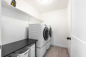 Washroom featuring washer and clothes dryer and light wood-style floors