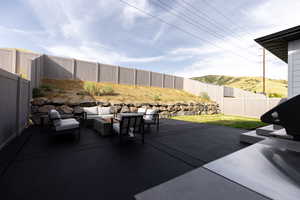 Fenced backyard featuring an outdoor hangout area and a patio