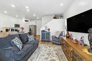 Living area with light wood-type flooring and recessed lighting