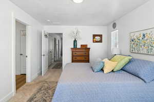 Bedroom with light carpet and a textured ceiling