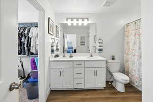 Full bath featuring double vanity and wood finished floors