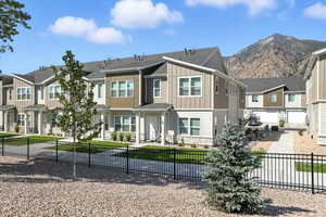 View of front of property featuring a residential view, stone siding, board and batten siding, and a shingled roof