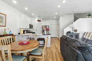 Dining room with light wood finished floors and recessed lighting