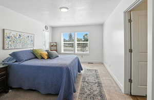 Bedroom with a textured ceiling and carpet