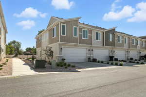 View of front facade with concrete driveway, a garage, board and batten siding, and a residential view