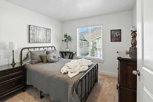 Bedroom with light colored carpet and baseboards