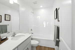 Full bath featuring vanity, wood finished floors, and bathtub / shower combination