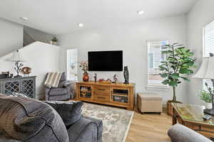 Living room with light wood-type flooring and recessed lighting