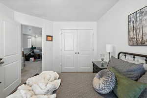 Carpeted bedroom featuring a closet and an office area