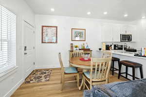 Dining space with light wood-style flooring and recessed lighting