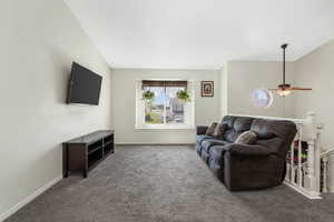 Carpeted living area featuring baseboards and a ceiling fan