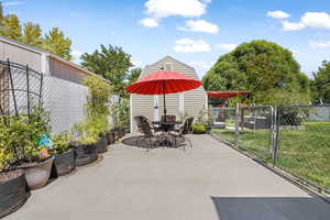 View of patio with a gate and outdoor dining area
