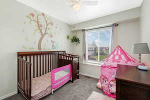 Carpeted bedroom featuring baseboards and ceiling fan