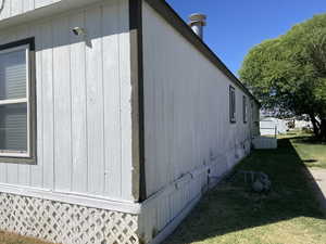 View of side of home with a yard