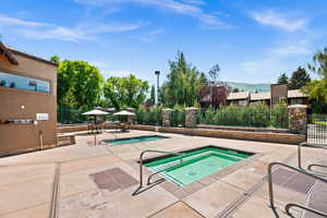 View of swimming pool featuring a community hot tub, a patio, a mountain view, and a pool