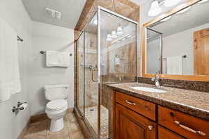 Full bathroom with tile patterned flooring, vanity, and a stall shower